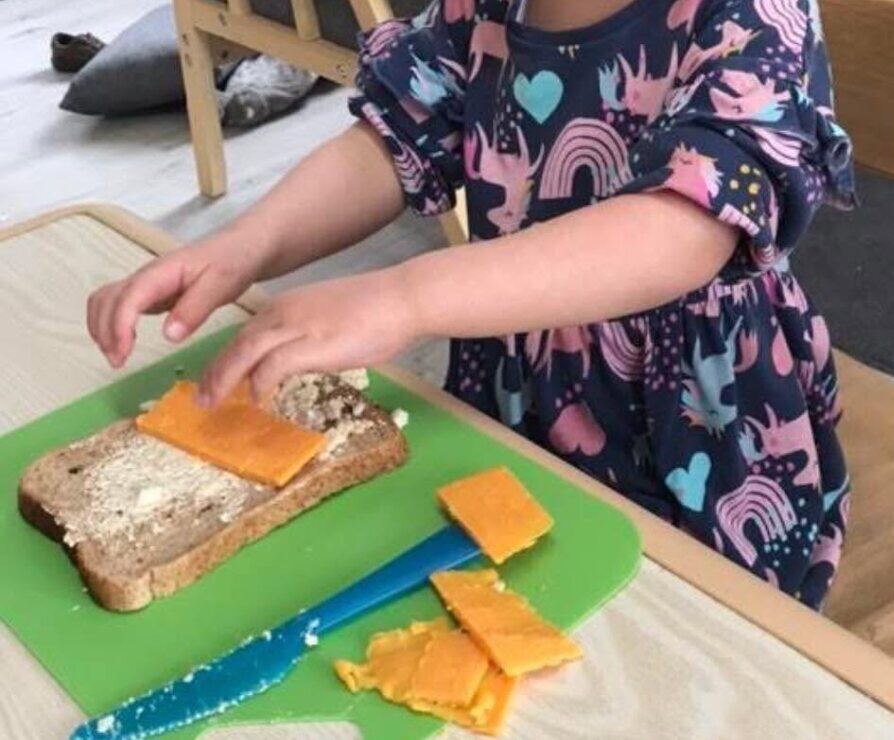 A child preparing a sandwich at Gilmerton